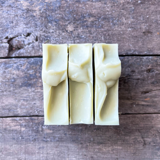 Three bars of soap on a wooden surface