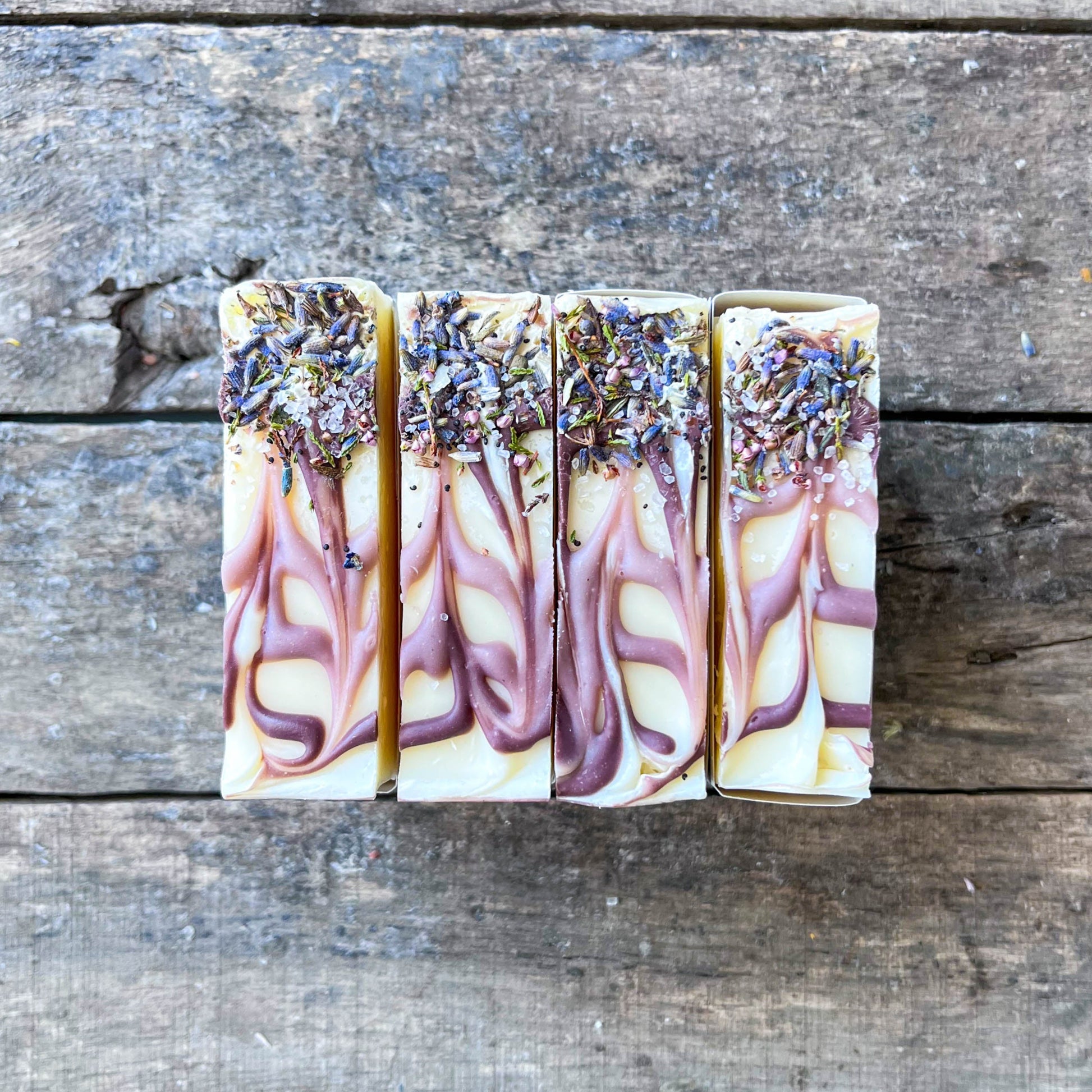 Four soap bars with floral design on a wooden surface