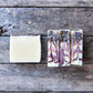 Three bars of soap with floral designs on a wooden surface