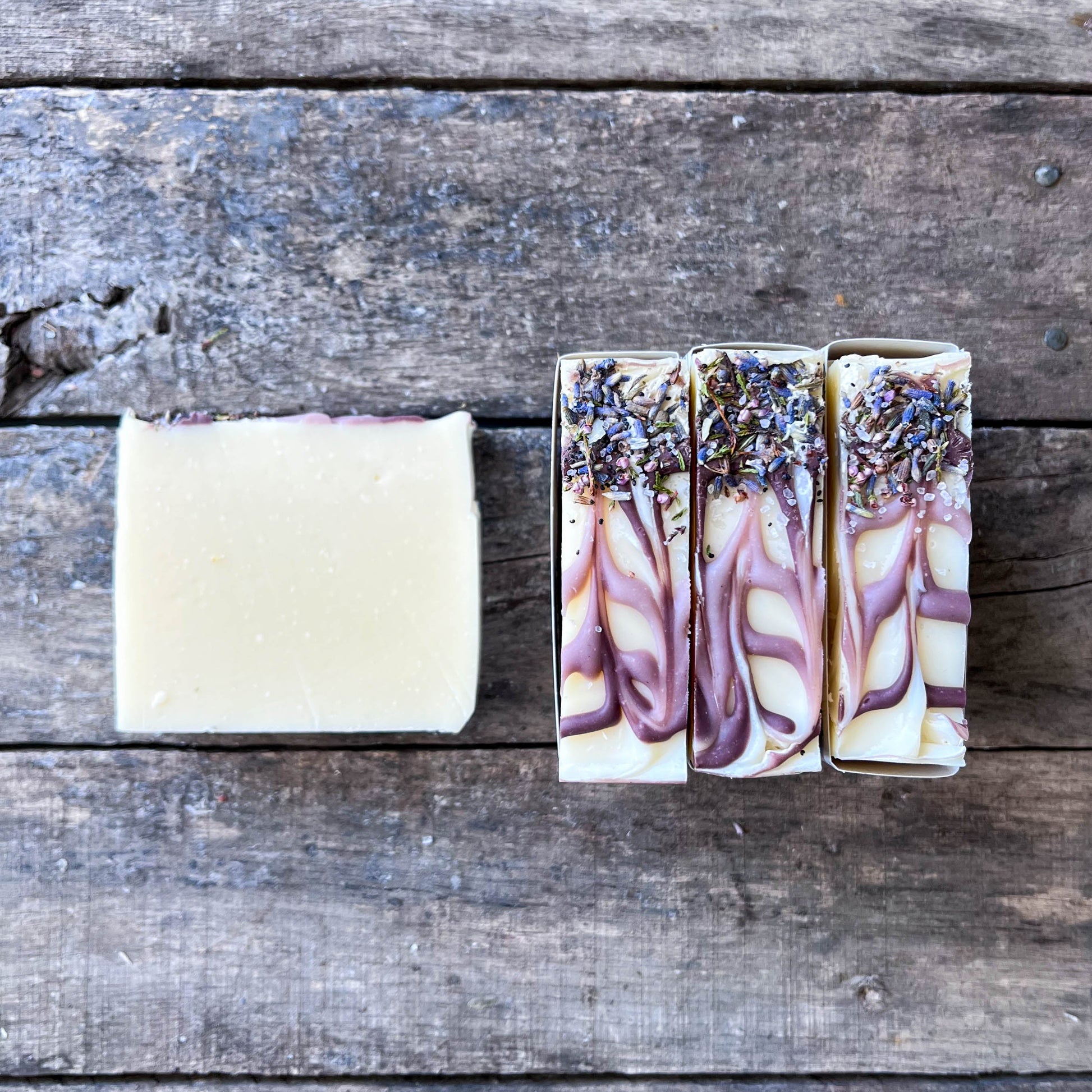 Three bars of soap with floral designs on a wooden surface
