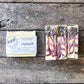Three soap bars with lavender on a wooden surface