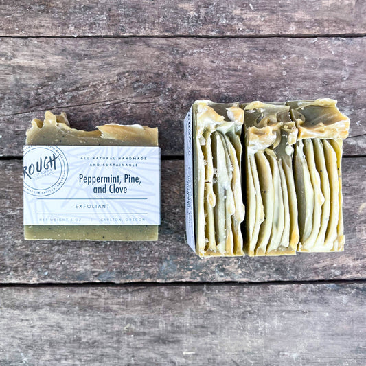Peppermint Pine and Clove Exfoliant Soap Bars with Poppy seeds on a wooden surface