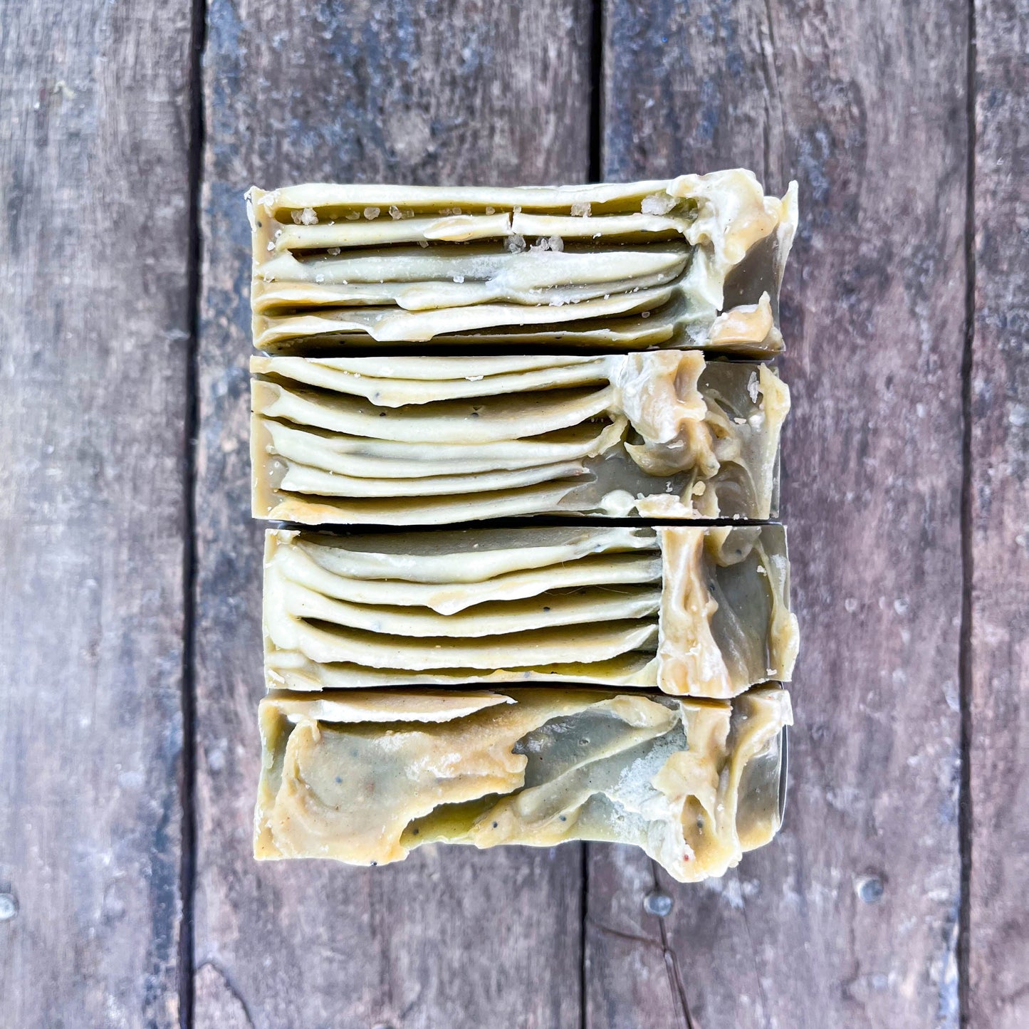Stack of layered soap bars on a wooden surface