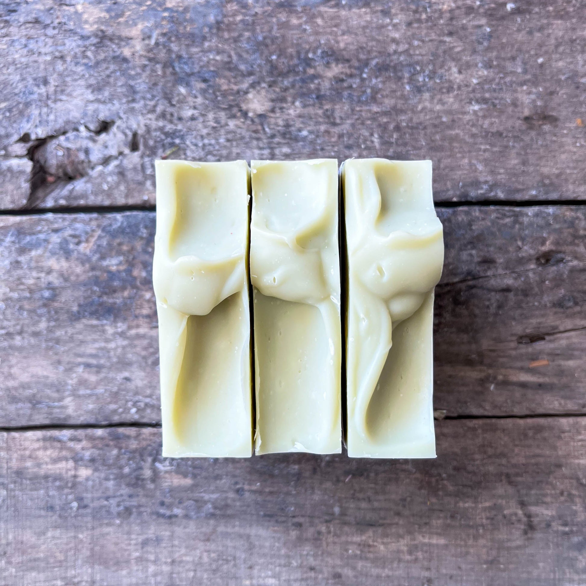 Three bars of soap  on a wooden surface